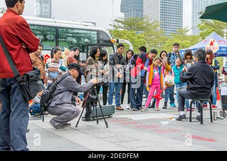 A Chinese man watching his camera and recording a man playing Chinese traditional musical instument Erhu in Shenzhen, China Stock Photo