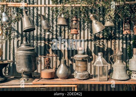 Old metal pots, copper jugs and samovar in antique shop close up Stock Photo