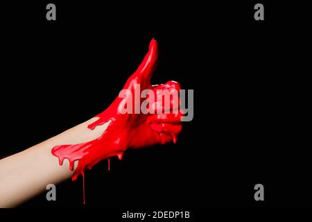 cropped view of hand painted in red paint showing thumb up isolated on black Stock Photo