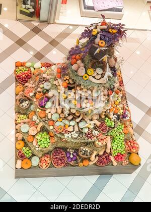 Autumn rustice decoration with big orange pumpkins and mixed autumn fruits and vegetables on on a large platform at the street in Bulgaria. Stock Photo