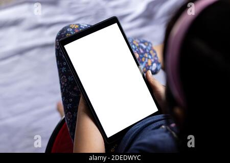 an indian girl child holding tablet with white blank screen in hand Stock Photo