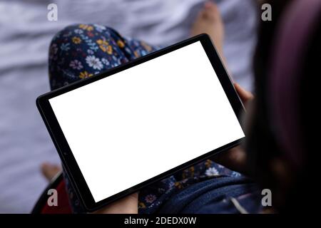an indian girl child holding tablet with white blank screen in hand Stock Photo