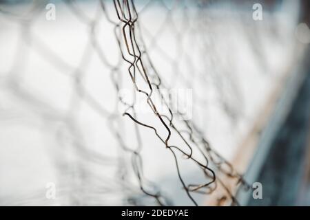 a chain link fence. wire mesh fence with snow on blurred background Stock Photo