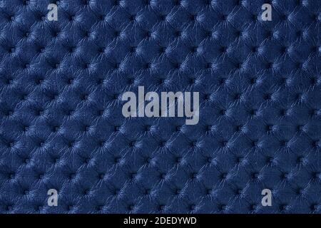 Texture of navy blue leather background with capitone pattern, macro. Indigo textile of retro Chesterfield style. Vintage sapphire fabric backdrop. Stock Photo