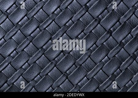 Texture of dark blue leather background with wicker pattern, macro. Abstract backdrop from modern decorative black textile with diagonal lines. Stock Photo