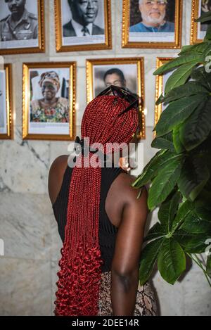 African woman looking at pictures of old leader in Ghana, one of the leader named Jerry Rawlings died on November 12 4 days after this photo was taken Stock Photo