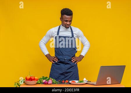 african chef using his laptop while cooking looking perplexed Stock Photo