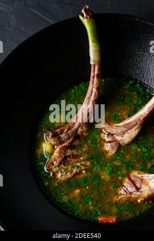 meat soup with a rack of lamb on a black background Stock Photo