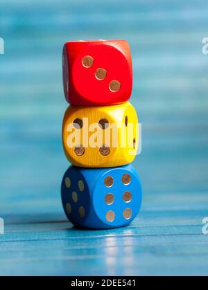 Three colorful board game dice stack. Multi colored dice laying on top of each other. Kids early school education symbol, simple educational materials Stock Photo
