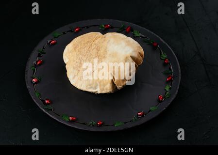Georgian vegetable salad in tortilla bread on a black background Stock Photo