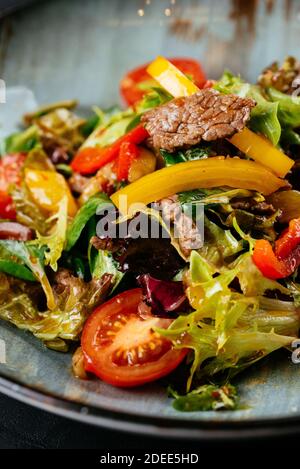 warm salad with marbled beef steak on a black background Stock Photo