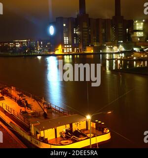 Wolfsburg, Germany, November 28., 2020: Harbor at the power plant of the car manufacturer Volkswagen at night with an anchored barge in the foreground Stock Photo