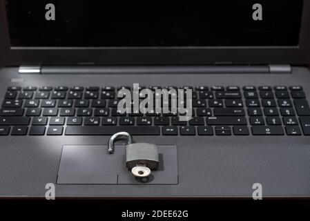 Metal lock unlocked - laptop on table, closeup - computer insecurity. Open to cyber attack. Selective focus Stock Photo
