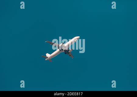 Large passenger plane flying in the blue sky. Transportation Stock Photo