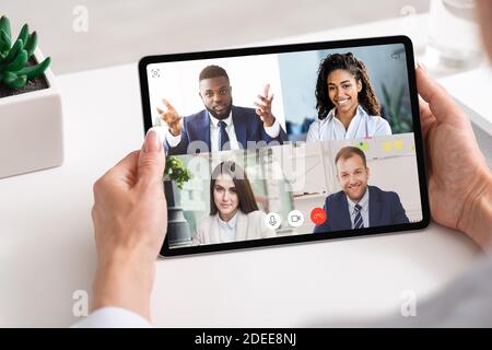 Business People Having Group Video Call Online Via Tablet Indoor Stock Photo