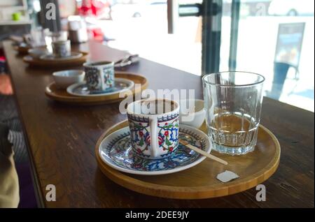 Empty cup of Turkish coffee with traditional patter in cafe and empty glass of water close up. Selective focus on first cup. Istanbul, Turkey. Stock Photo