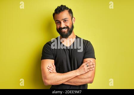 indian arab ith a happy and cool smile on face isolated on green studio background. portrait of lucky person, good mood Stock Photo
