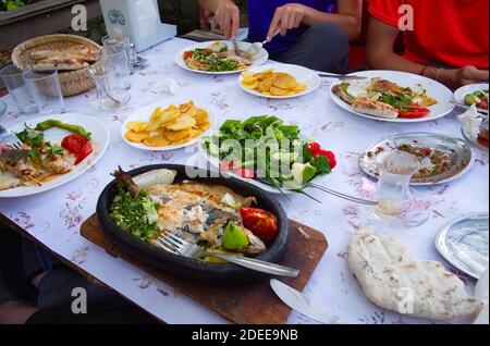 Plates with different Turkish food in a restaurant in a small village in mountains. Big variety of traditional local cuisine on table. Stock Photo