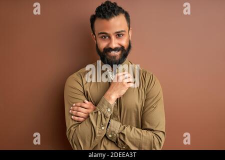 indian arab ith a happy and cool smile on face isolated on brown o background. portrait of lucky person, good mood Stock Photo