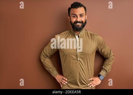 indian arab ith a happy and cool smile on face isolated on brown o background. portrait of lucky person, good mood Stock Photo