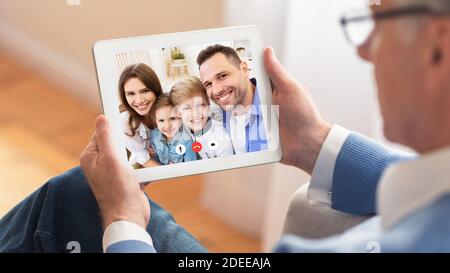 Senior Man Talking With Family Online Using Tablet At Home Stock Photo