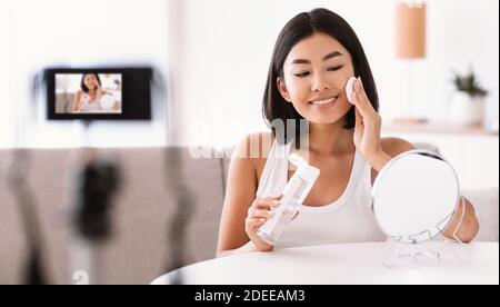 Young woman cleaning her face with cotton pad Stock Photo