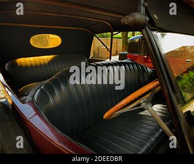 Wide angle view of interior very old automobile. Black leather seats inside vintage car. Stock Photo