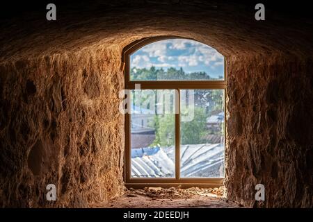 Arched window with a rectangular frame in the recess of the old red brick wall. From the Windows of the world series. Stock Photo