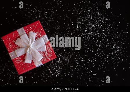 Red gift box with a white bow on a black background Stock Photo