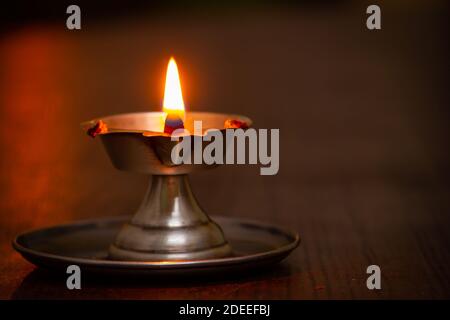 Close view of lit diya lamp. Lamp made out of silver metal lit during festival. Stock Photo