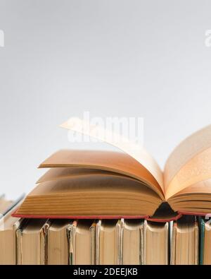 Open book on white background, hardback books on wooden table. Education and learning background. Back to school, studying. Copy space for text Stock Photo