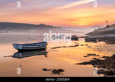 After a cold night in North Devon, mist rises from a tranquil River Torridge, with the pastel colours of sunrise reflecting in the outgoing estuary ti Stock Photo