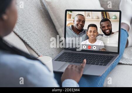 Black Family Having Video Call Online Using Laptop At Home Stock Photo