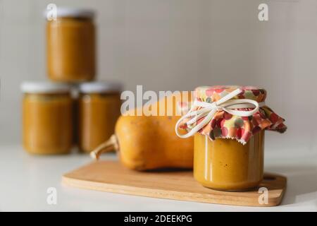 Pumpkin preserves jars on wooden board and white background Stock Photo