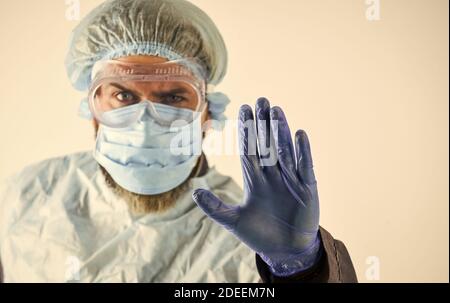 Stop. Personal protective equipment. Man wearing protective mask. Coronavirus pandemic. Garments protect health. Infection prevention. Face protection goggles mask head cover. Dangerous zone. Stock Photo