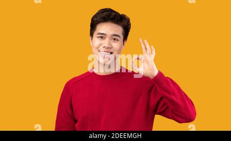 Happy asian man gesturing okay and smiling Stock Photo