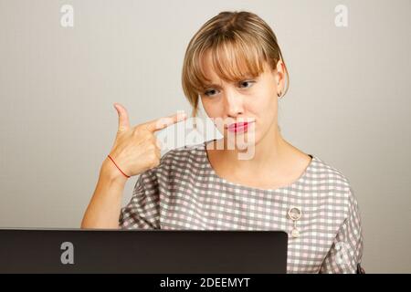 beautiful young girl thinking in the office at the computer Stock Photo