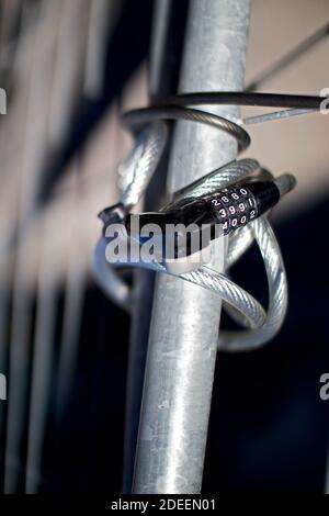 bicycle lock with numeric code attached to a metal grille Stock Photo