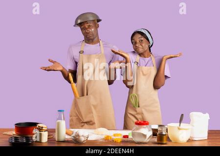 disaster home cook at kitchen- young funny and desperate man in cooking  apron holding pot in flames in stress and fear making a mess of fire and  smoke with food burning Stock