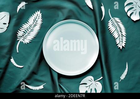 Tidewater green color. Creative trendy flat lay with exotic paper leaves on dark textile background Stock Photo