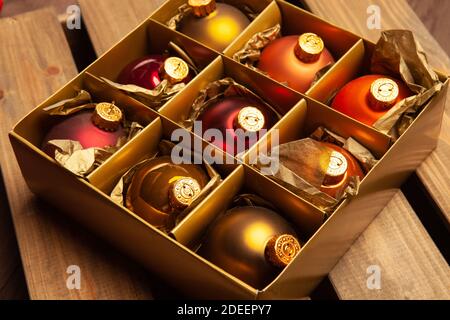 Vintage Christmas - box of colorful Christmas tree baubles on aged wooden background. Stock Photo
