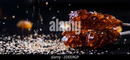 Candy cane sugar, brown sugar sticks on a dark table, selective focus Stock Photo