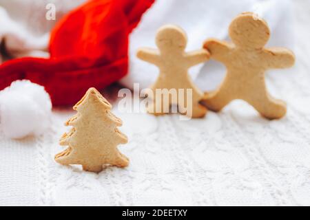 Christmas background with gingerbread tree nd two men, Santa hat on cozy white sweater Stock Photo