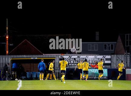 A fan watches from over the stadium fence as Canvey Island players make their way out onto the pitch prior to the beginning of the Emirates FA Cup second round match at Park Lane, Canvey Island Stock Photo