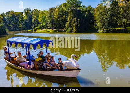 Tourists enjoy a gondola trip on the lake in Lazienki Park. Lazienki Park or Royal Baths Park is the largest park in Warsaw, Poland, occupying 76 hect Stock Photo
