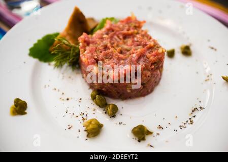 Traditional polish food: tartar z poledwicy wolowej siekany z jajem ekologicznym - Steak Tartare with pickles, fresly prepared from polish beef loin . Stock Photo
