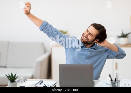 Man Massaging Aching Neck After Work At Computer In Office Stock Photo