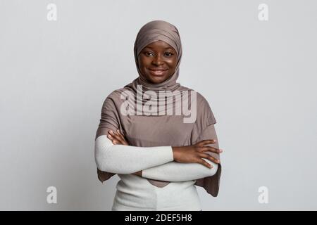 Portrait Of Beautiful Black Muslim Woman In Hijab Posing With Folded Arms Stock Photo