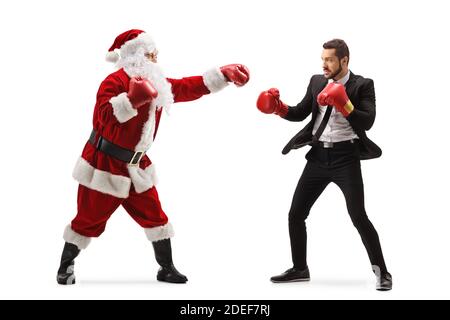 Full length profile shot of santa claus boxing with a businessman isolated on white background Stock Photo