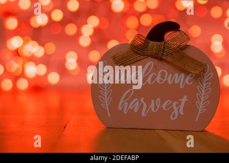 A Light Orange Wood Pumpkin That Says With Orange Bokeh Behind It Stock Photo